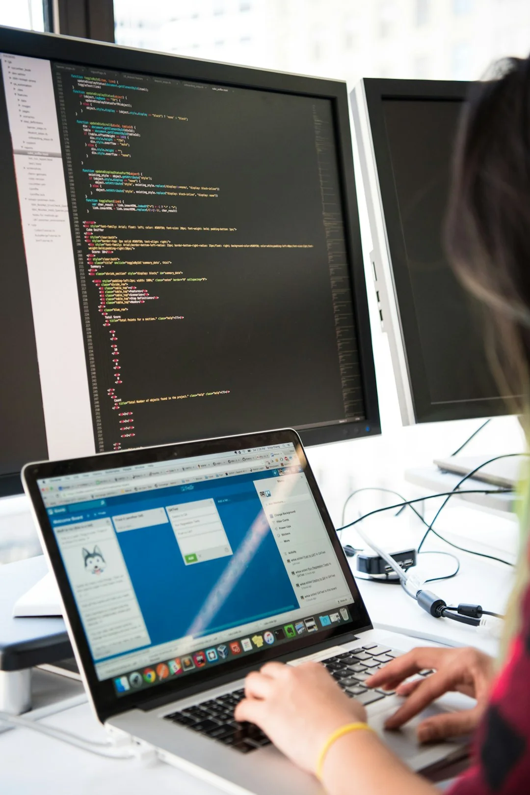 Une femme savoure un café tout en naviguant sur le web sur un ordinateur portable, installée à son bureau dans un espace de travail à domicile.