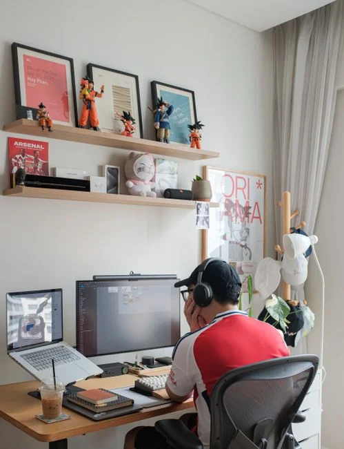Woman in floral dress shopping online with a laptop and credit card indoors.